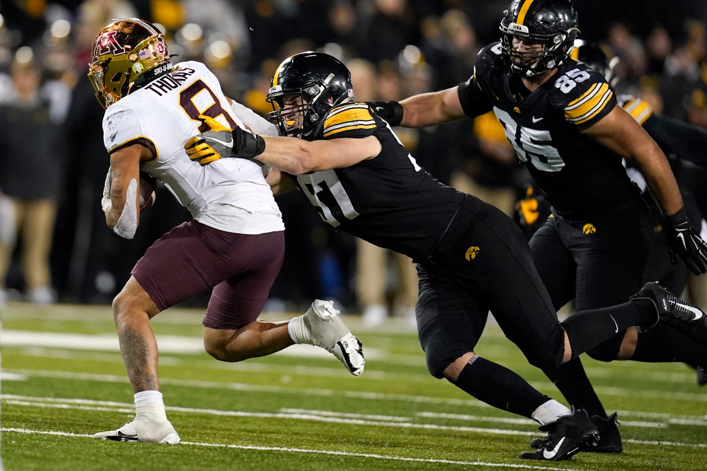 Iowa defensive lineman Zach VanValkenburg tackles Minnesota running back Ky Thomas (8) during the second half of an NCAA college football game, Saturday, Nov. 13, 2021, in Iowa City, Iowa. Iowa won 27-22. (AP Photo/Charlie Neibergall)