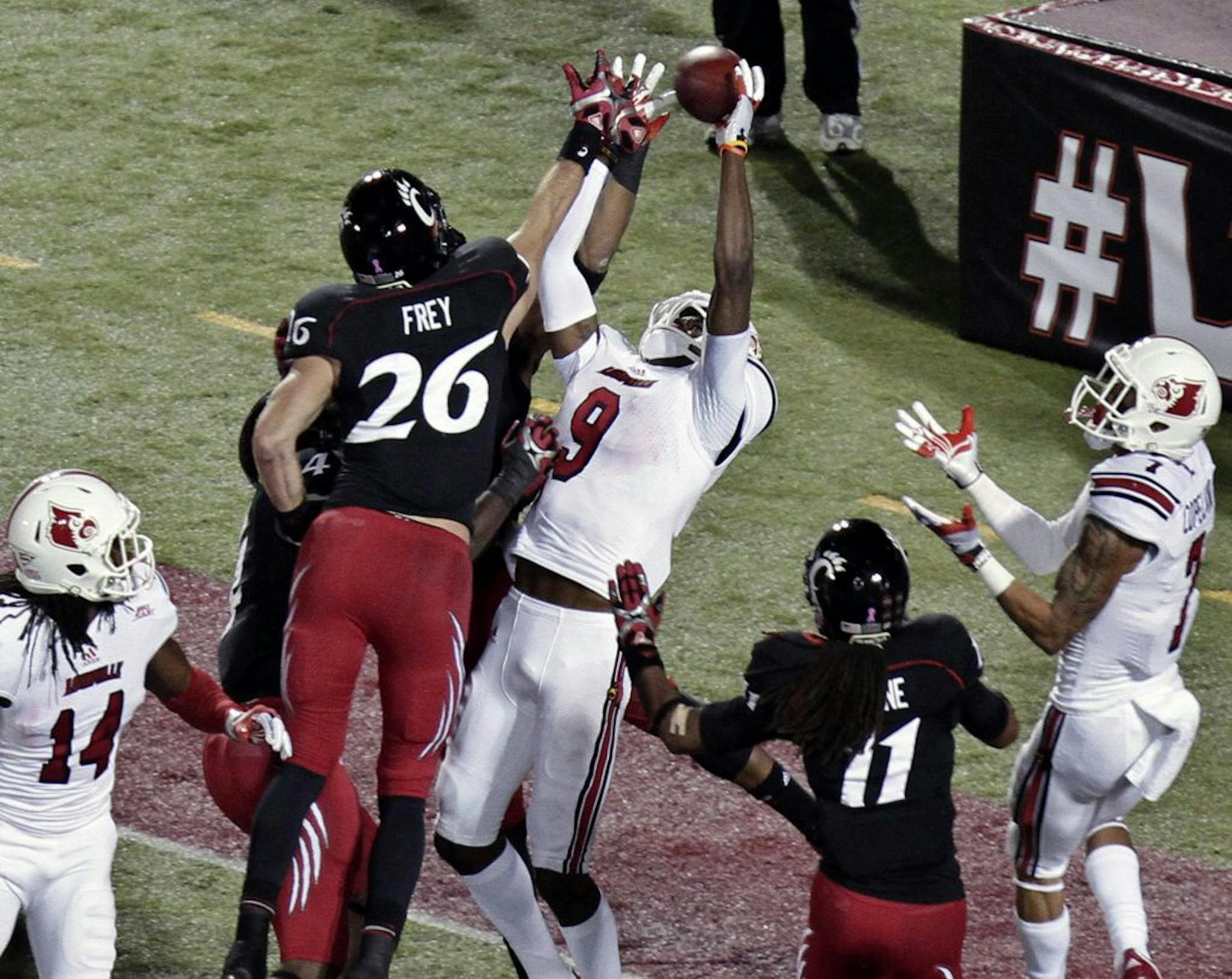 Louisville wide receiver DeVante Parker (9) tries to pull in a pass in the end zone, while surrounded by Cincinnati defenders Drew Frey (26), Arryn Chenault, behind Frey, and Deven Drane (11) on the last play of the first half in an NCAA college football game in Louisville, Ky., Friday, Oct. 26, 2012. Parker could not hold on to the ball. At right is Louisville's Damian Copeland (7).