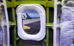 Delta and Icelandair planes are seen through the window of a door plug area on an Alaska Airlines Boeing 737 Max 9 aircraft awaiting inspection at the