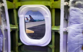 Delta and Icelandair planes are seen through the window of a door plug area on an Alaska Airlines Boeing 737 Max 9 aircraft awaiting inspection at the
