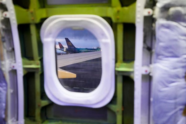 Delta and Icelandair planes are seen through the window of a door plug area on an Alaska Airlines Boeing 737 Max 9 aircraft awaiting inspection at the