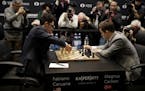 Reigning chess world champion Magnus Carlsen, right, from Norway, plays Italian-American challenger Fabiano Caruana in the first few minutes of round 