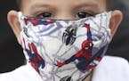 A boy wears a protective face mask with a Spiderman motif as a measure to help curb the spread of the new coronavirus, in Bogota, Colombia, Thursday, 