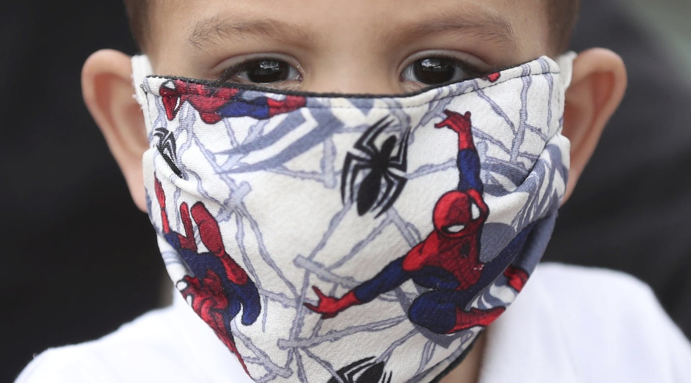 A boy wears a protective face mask with a Spiderman motif as a measure to help curb the spread of the new coronavirus, in Bogota, Colombia, Thursday, April 30, 2020. (AP Photo/Fernando Vergara)