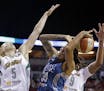 Minnesota Lynx's Seimone Augustus, center, is double-teamed by Seattle Storm's Abby Bishop, left, of Australia, and Markeisha Gatling during the first