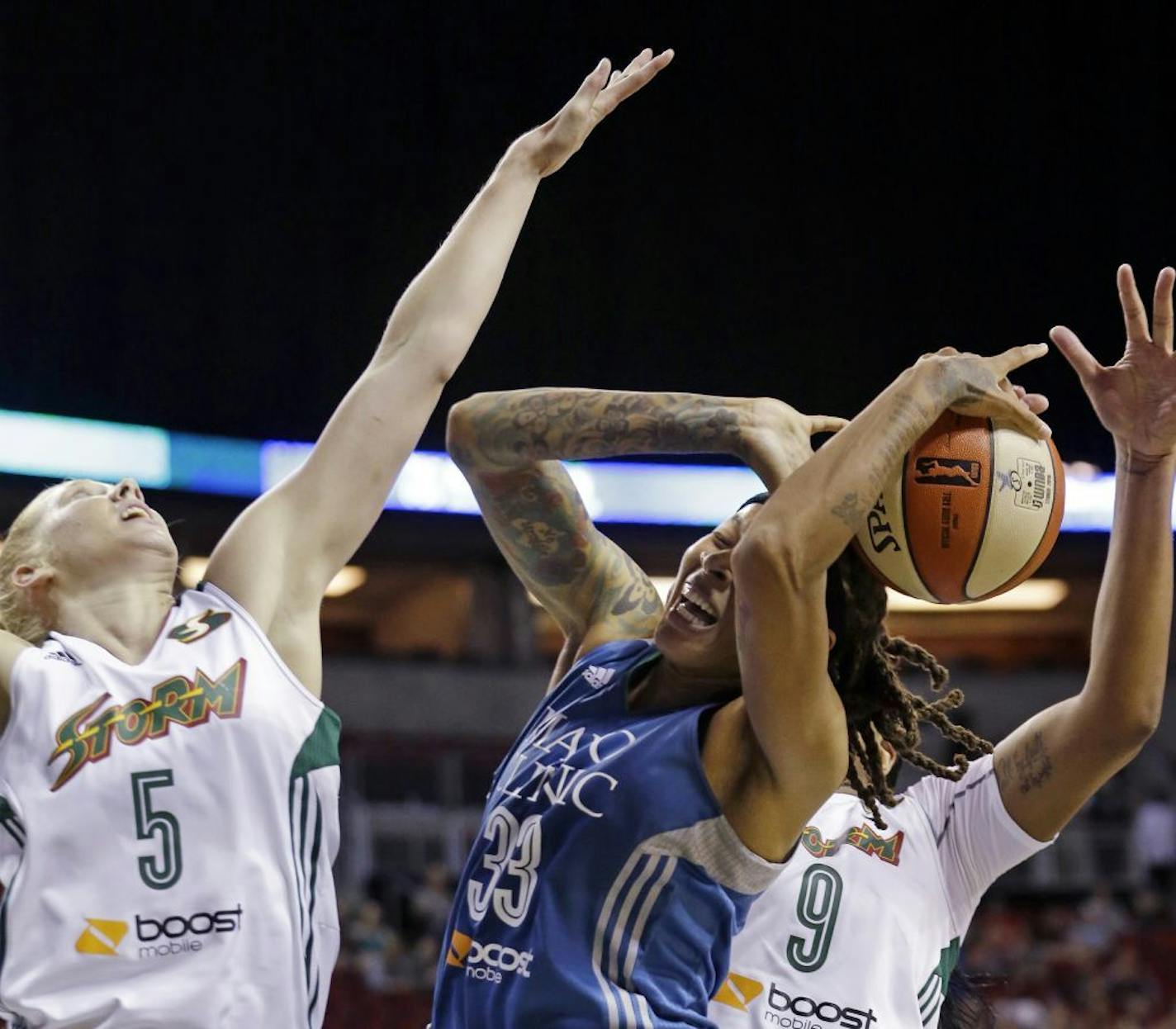 Minnesota Lynx's Seimone Augustus, center, is double-teamed by Seattle Storm's Abby Bishop, left, of Australia, and Markeisha Gatling during the first half of a WNBA basketball game Thursday, June 25, 2015, in Seattle.