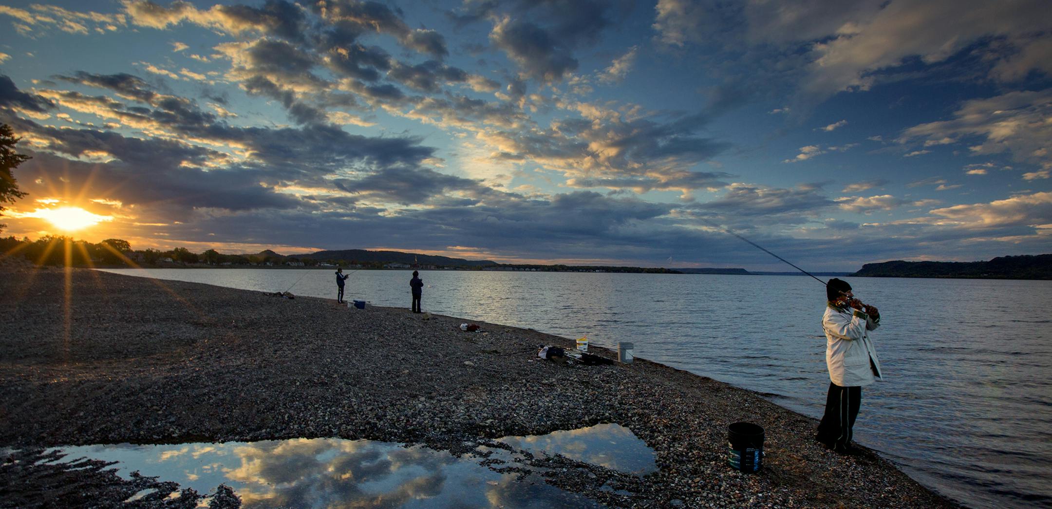 Fishermen gather along a gravel bar on the shore of Lake Pepin as the sun sets in the west on a cool fall evening. ] Minnesota State of Wonders travel Project - South East Minnesota Bluff Country. BRIAN PETERSON &#x2022; brian.peterson@startribune.com Lake City, MN 10/13/14 ORG XMIT: MIN1410291716418908