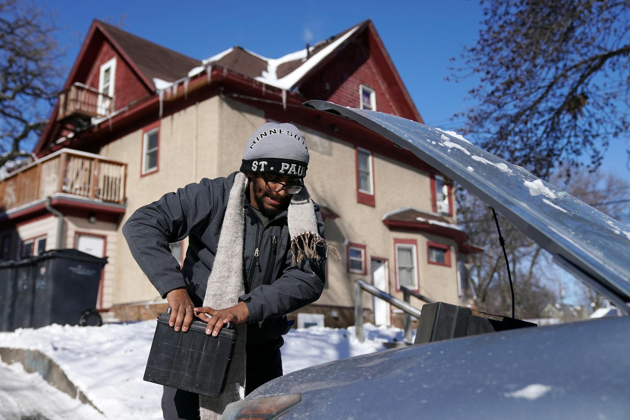 Hussameldin Mustafa, a freshman at the University of Minnesota studying international business, worked to change the battery on his car after it wouldn't start due to the extreme cold Wednesday.