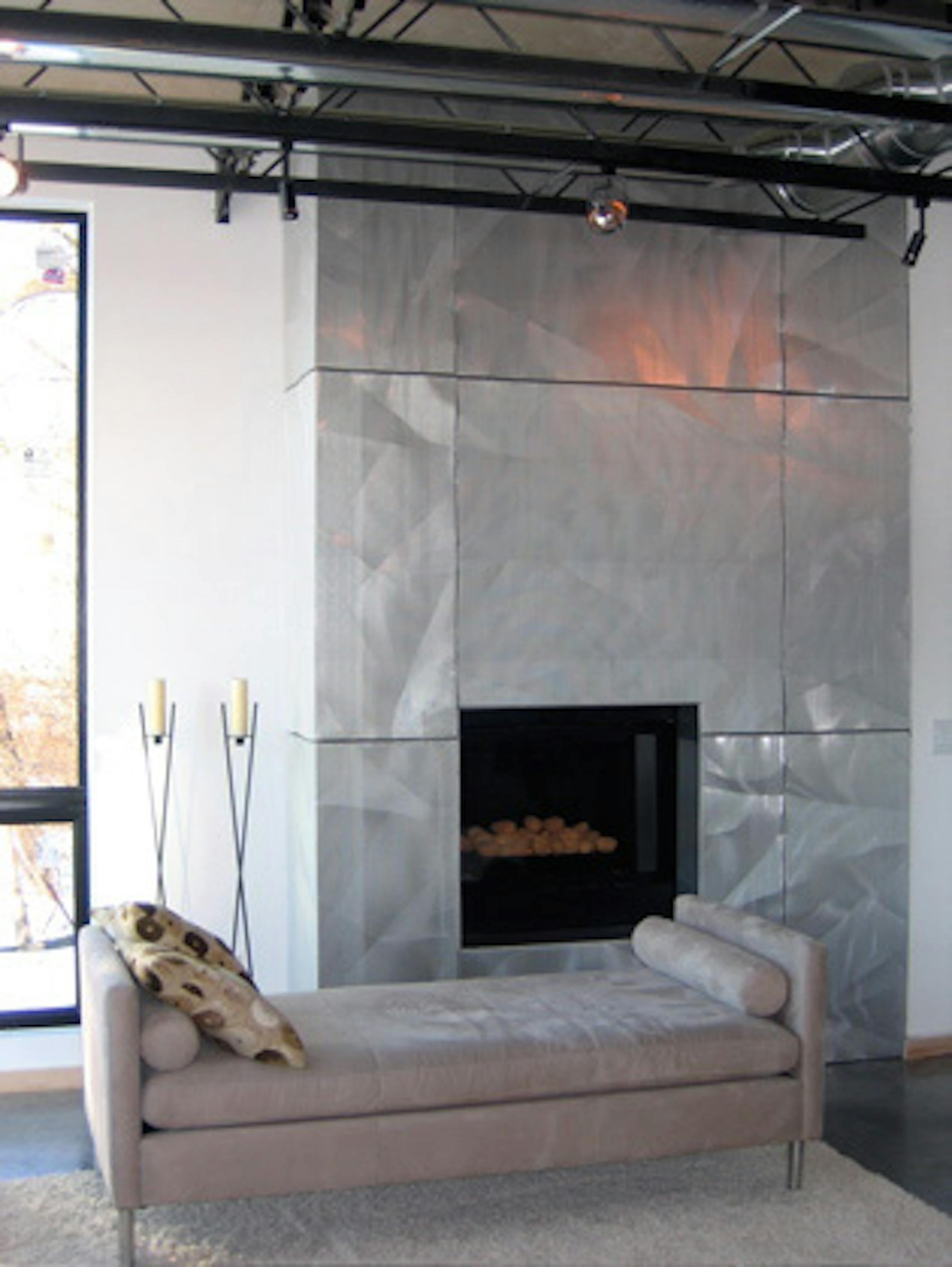 Inspired by the Walker Art Center addition, the Hammonds bought leftover pieces of the architectural sheet metal to use in their fireplace surround. The crumpled pattern catches the light and accents every angle.