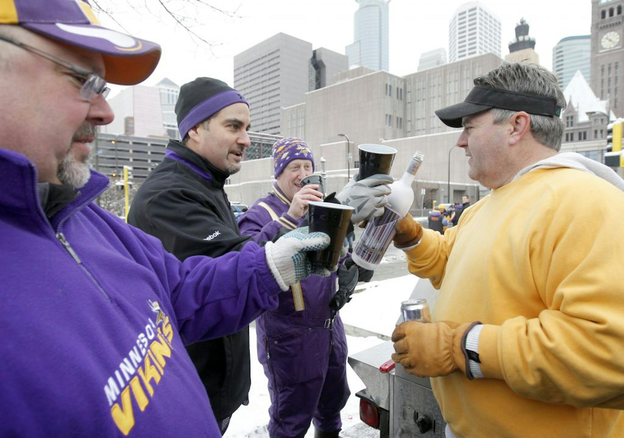 Paul Thielman (left) shared a toast with friends as they tailgated before the Vikings-Broncos game.