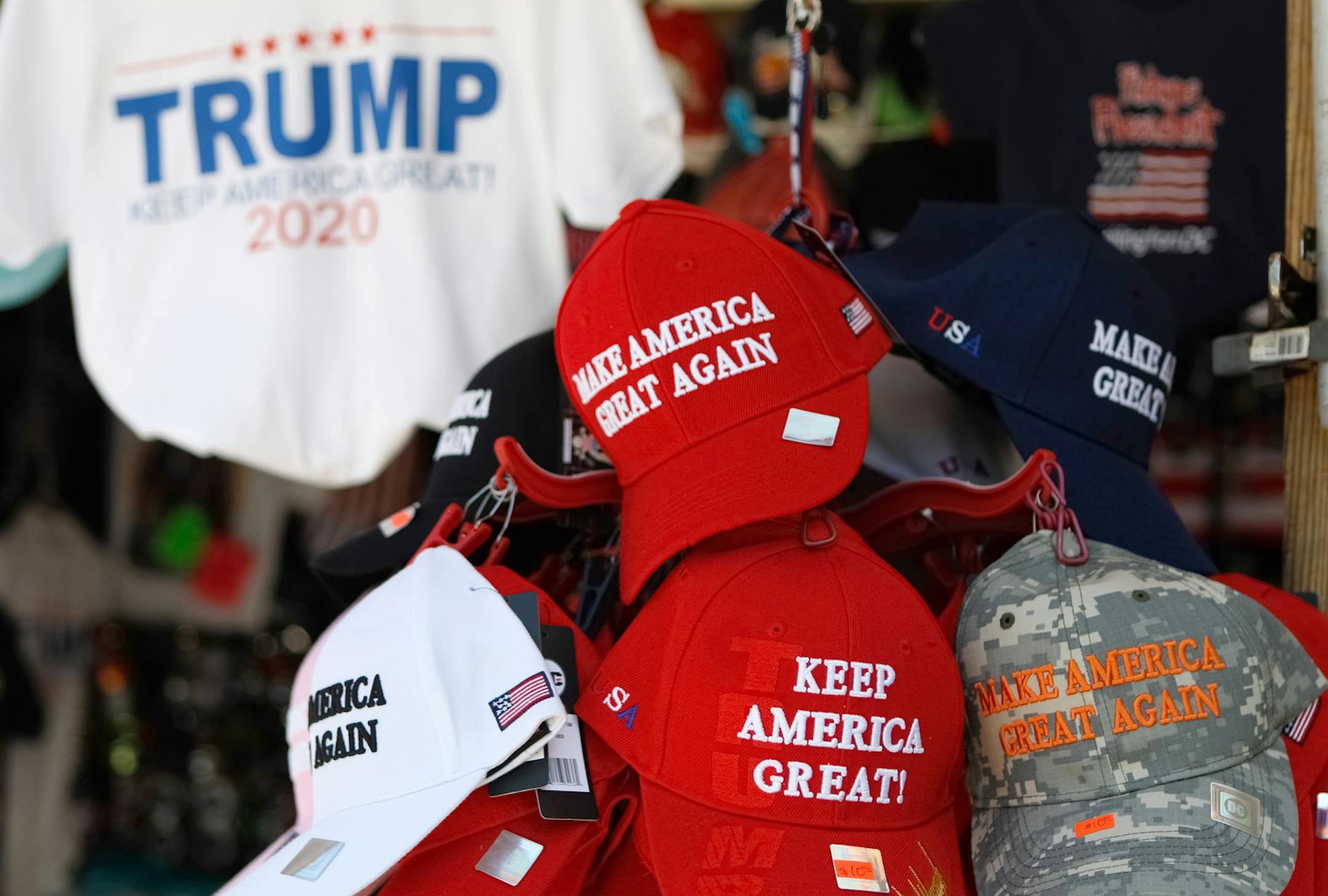 Washington, D.C., USA - July 21, 2019: A street vendor selling public domain Donald Trump paraphernalia and souvenirs. The souvenirs are located right across the street from the White House and taken on the afternoon of July 21, 2019 near Pennslyvania Avenue in Washington, D.C. The red hat is a signature symbol of his "brand". Donald Trump for President "Make America Great Again"