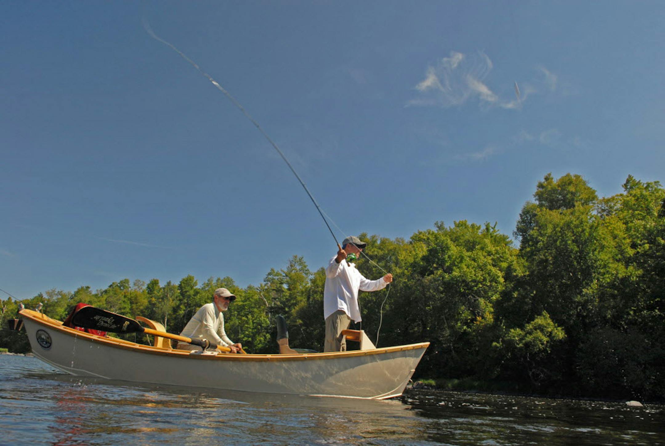 Todd Sether of the Twin Cities casts a fly on Wisconsin's Chippewa River, looking for smallmouth bass and muskies, while guide Larry Mann positions his drift boat.