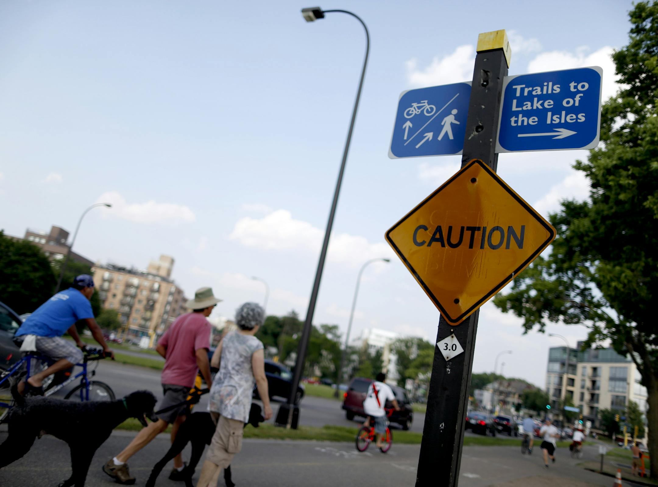 Pedestrians, cyclists and joggers passed by the northeast corner of Lake Calhoun near Lake St. in Minneapolis on Wednesday evening. ] CARLOS GONZALEZ cgonzalez@startribune.com July 10, 2013, Minneapolis, Minn., Is a land bridge over Lake Street the fix for summer congestion at the northeast corner of Lake Calhoun, where users of the Chain of Lakes, the state's busiest park, intersect with the busiest Hennepin County's county highway? That's one idea being advocated for alleviating the clash of j