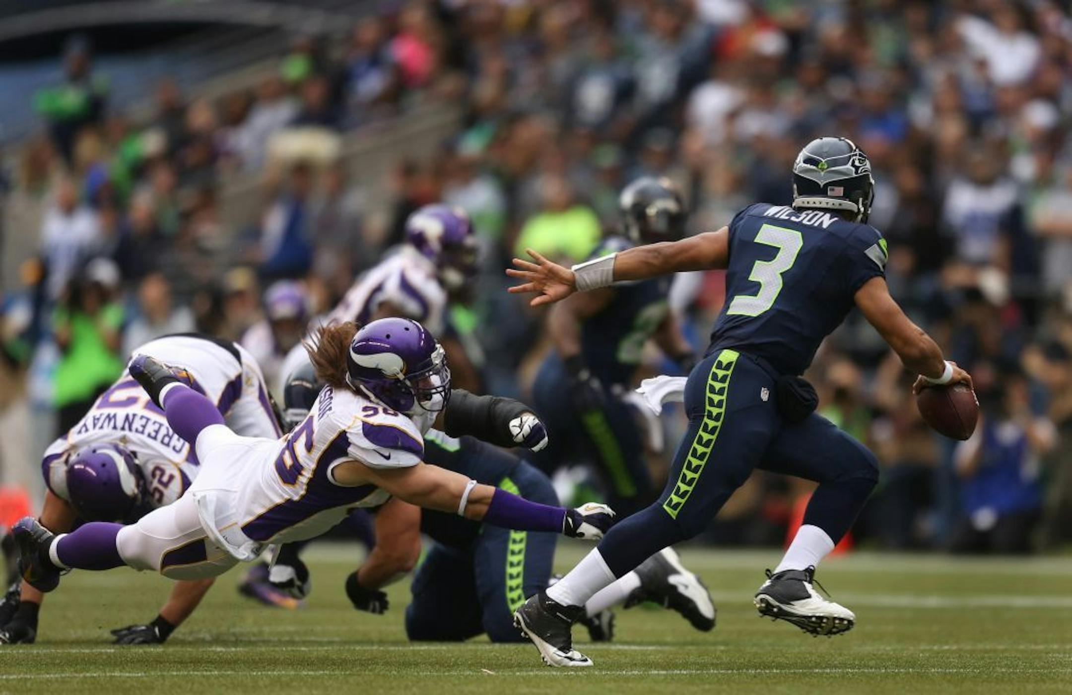 Seahawks quarterback Russell Wilson avoided a sack from defensive end Brian Robison in the second quarter.
