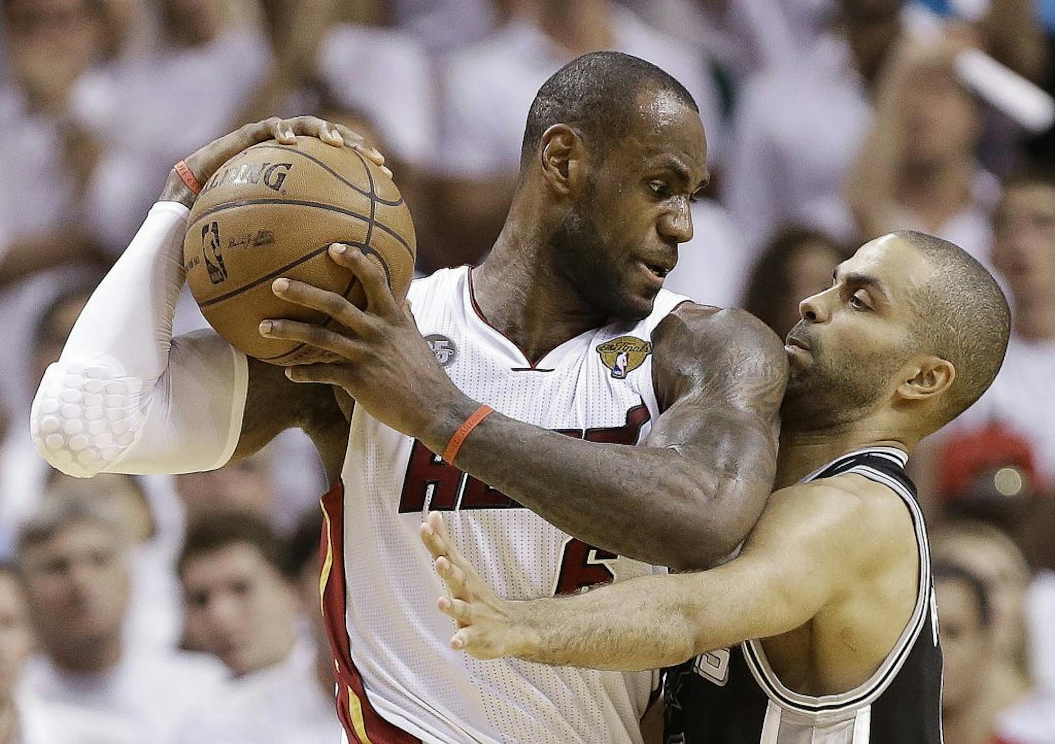 San Antonio Spurs guard Tony Parker (9) and Miami Heat forward LeBron James (6) collide during the second half of Game 6 of their NBA Finals basketball series, Tuesday, June 18, 2013 in Miami.