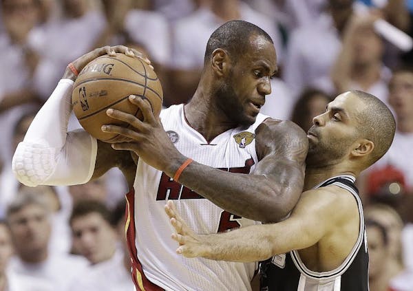 San Antonio Spurs guard Tony Parker (9) and Miami Heat forward LeBron James (6) collide during the second half of Game 6 of their NBA Finals basketbal