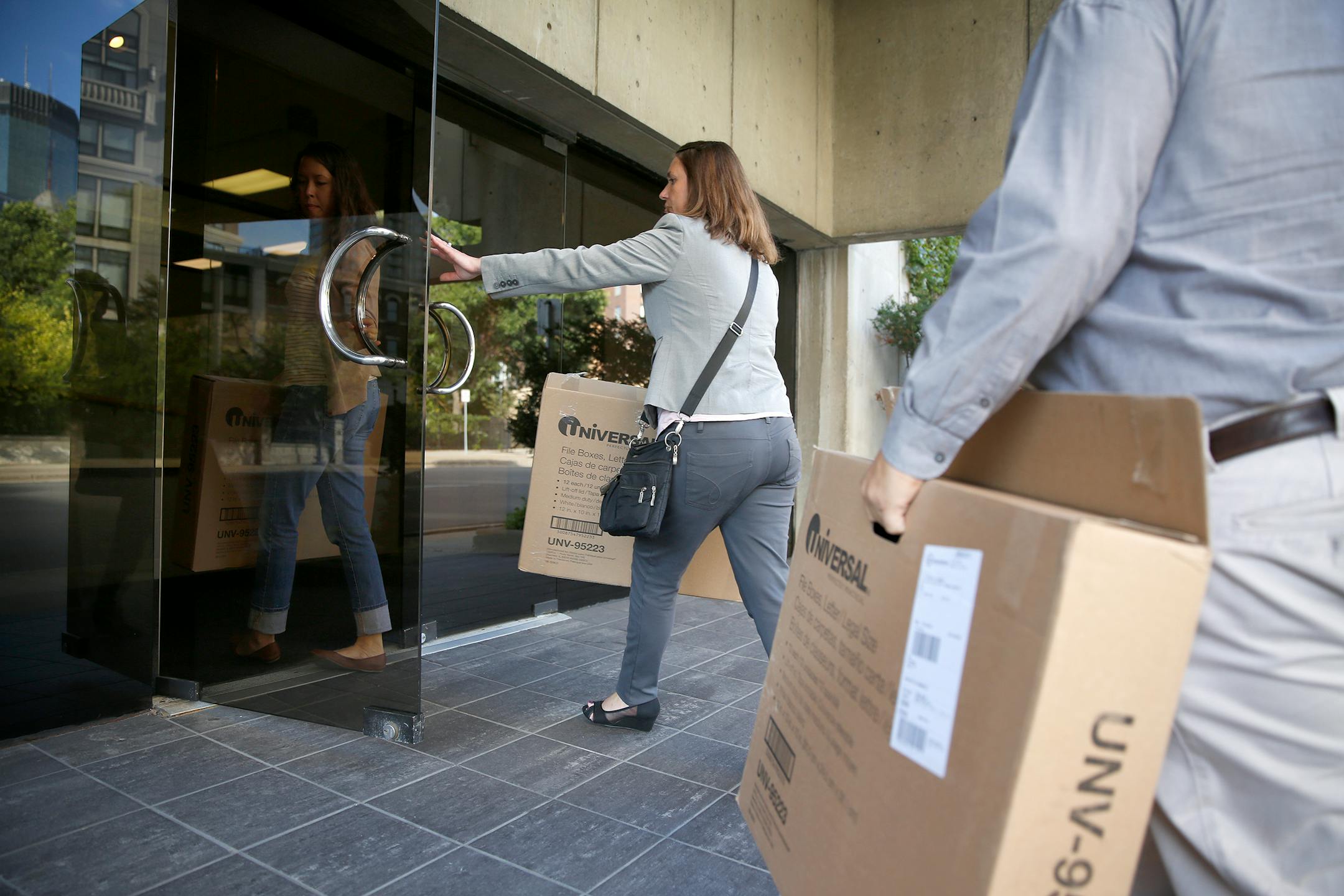 State officials bring boxes into the offices of the Community Action of Minneapolis during a raid on Friday, September 26, 2014. ] LEILA NAVIDI leila.navidi@startribune.com /