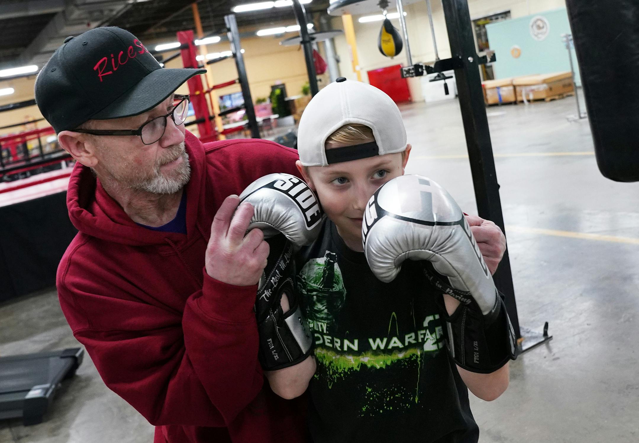 Mike Evgen explained technique to Soren Holdahl, 10, as they worked out with a punching bag. ] ANTHONY SOUFFLE • anthony.souffle@startribune.com Mike Evgen, the former Rice Street Rocker of area pro boxing fame, worked out with some of his fighters at his new boxing gym the Rice Street Old School Boxing Gym (though it's not on Rice Street) Thursday, Jan. 23, 2020 in St. Paul, Minn.