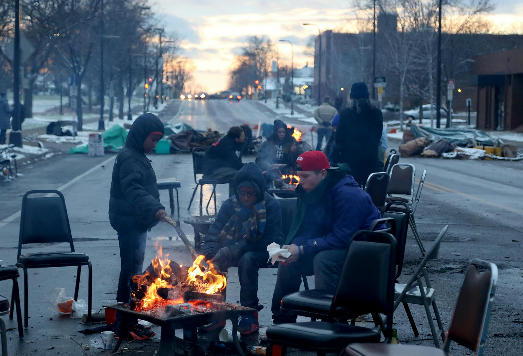 Community members and protesters warmed themselves by the fire during BlackGiving event in front of the Minneapolis Fourth Precinct.