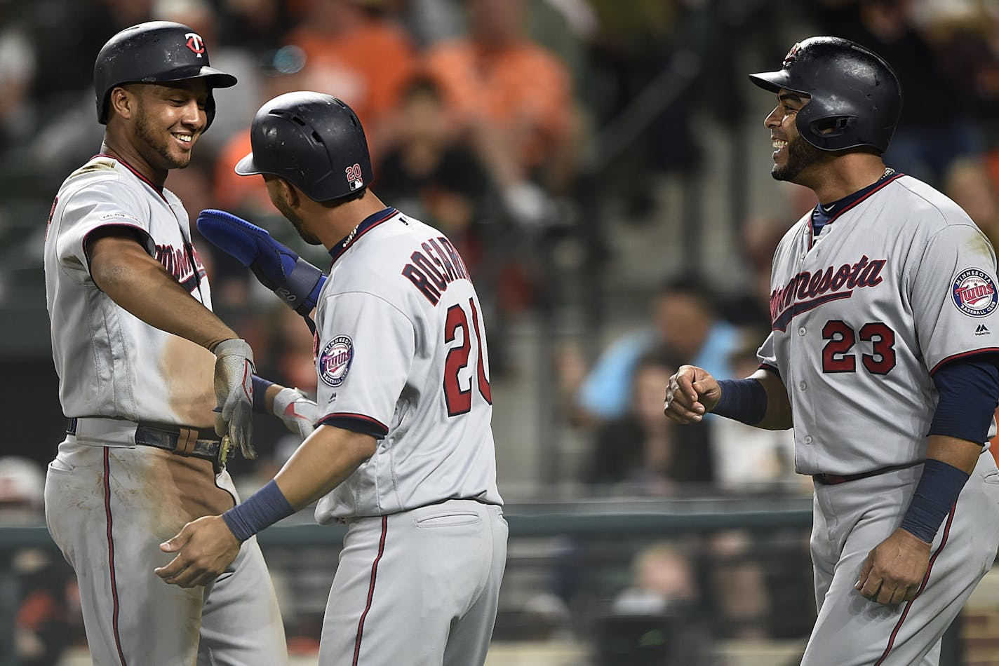 Minnesota Twins Jonathan Schoop, left, is congratulated by Eddie Rosario, center, and Nelson Cruz after hitting a three-run home run against the Baltimore Orioles in the fourth inning of the second game of a baseball doubleheader, Saturday, April 20, 2019, in Baltimore.