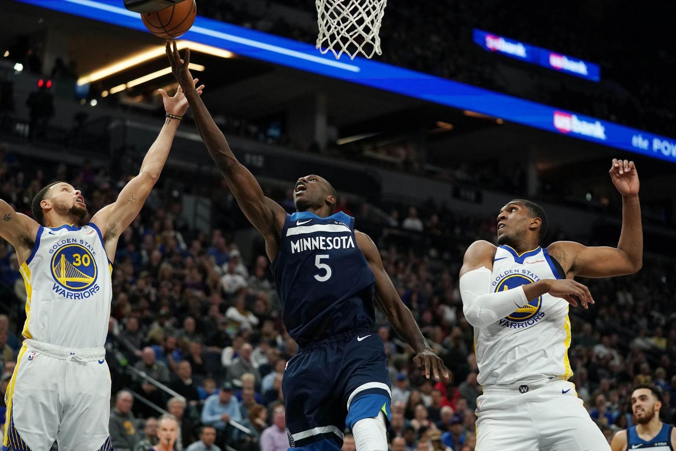 Minnesota Timberwolves center Gorgui Dieng (5) went up against Golden State Warriors guard Stephen Curry (30) for a rebound in the second half.