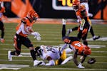 Cincinnati Bengals' Vonn Bell (24) and Jordan Evans (50) look to recover a fumble by Pittsburgh Steelers' JuJu Smith-Schuster (19) during the first ha