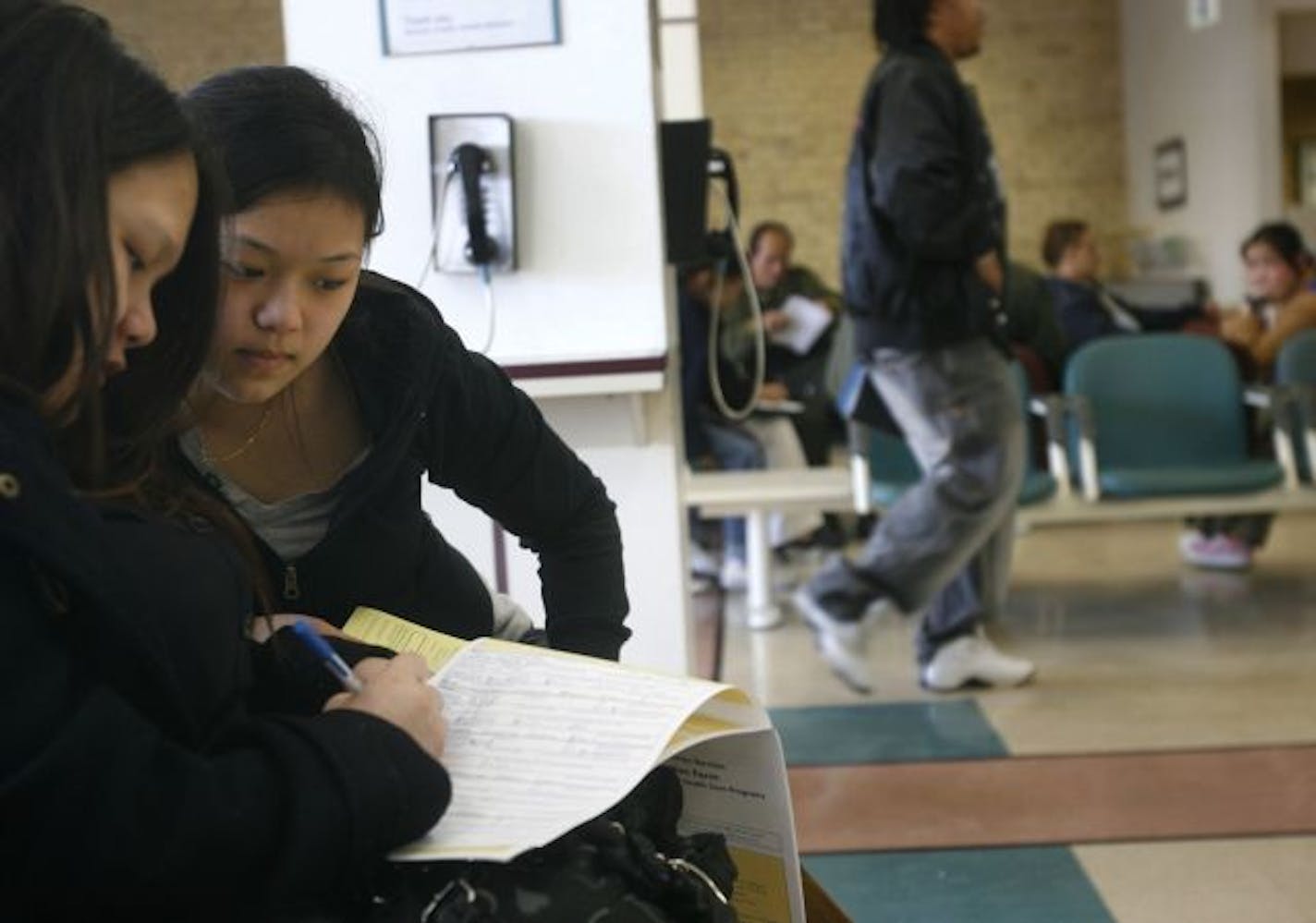 Desire Vang, right, received help filing for public assistance from her aunt, Nou Lee, at the Ramsey County Government Center last week. Officials expect such first-time applicants to increase as the economy worsens.