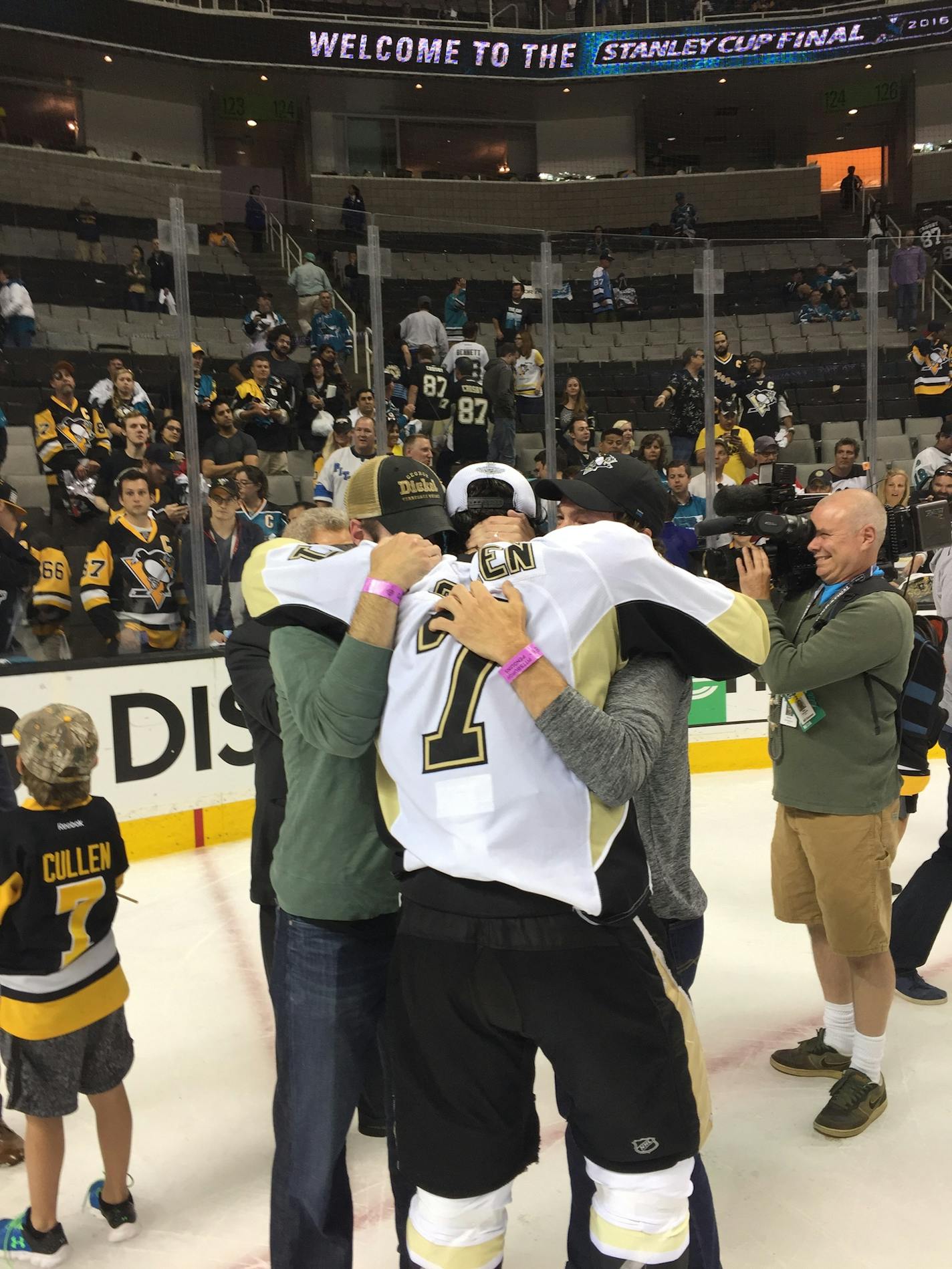 Matt Cullen after winning the Stanley Cup in June is embraced by brothers Joe and Mark.