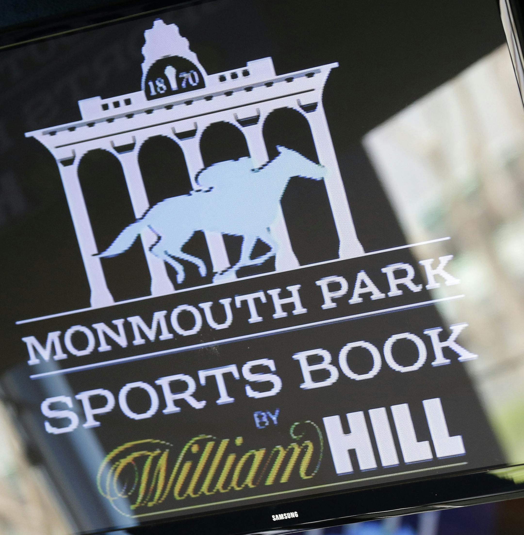 Signs for Monmouth Park are displayed in a bar at the racetrack in Oceanport, N.J., Monday, May 14, 2018. The Supreme Court on Monday gave its go-ahead for states to allow gambling on sports across the nation, striking down a federal law that barred betting on football, basketball, baseball and other sports in most states. (AP Photo/Seth Wenig)
