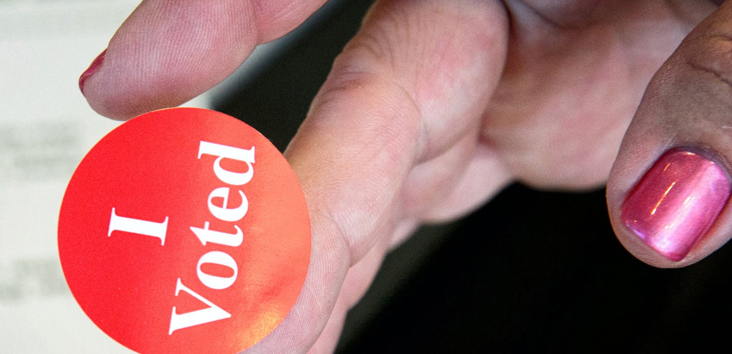 A poll worker offered an I Voted sticker to a voter.