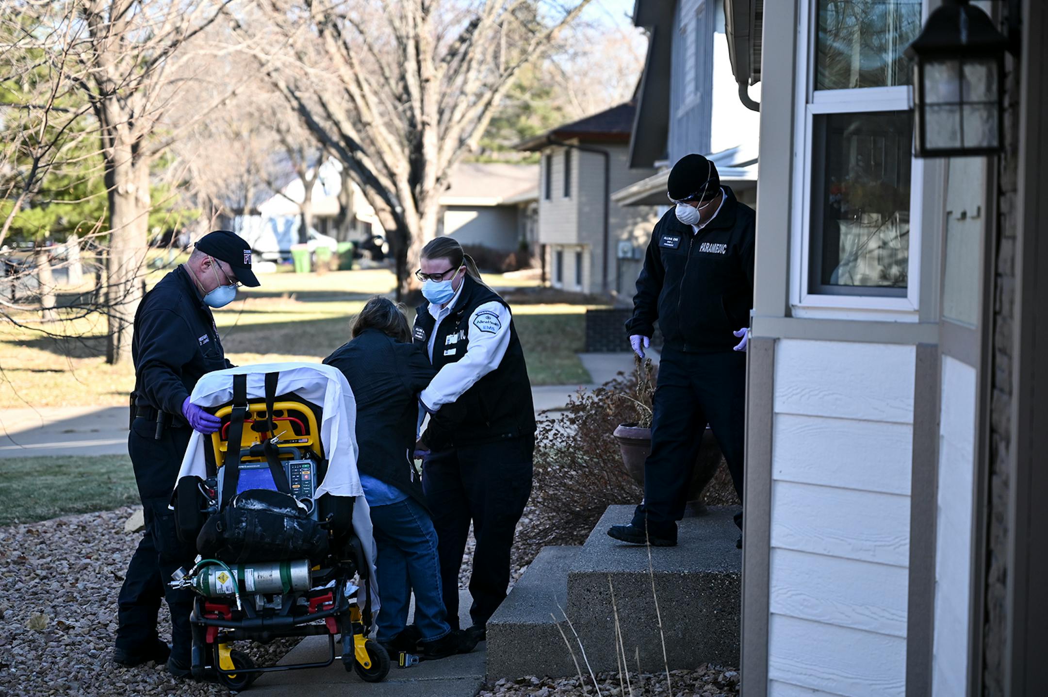 A woman, having a suspected COVID-19 related medical emergency, was helped by emergency first responders including, from left, Coon Rapids firefighter Darin Jahnke, and Allina Health paramedics Kelsey Cook and Dan Lennartson. ] AARON LAVINSKY • aaron.lavinsky@startribune.com Emergency medical workers and physician Andrew Stevens responded to possible COVID-19 related calls on Wednesday, Dec. 2, 2020 in the north Twin Cities metro.