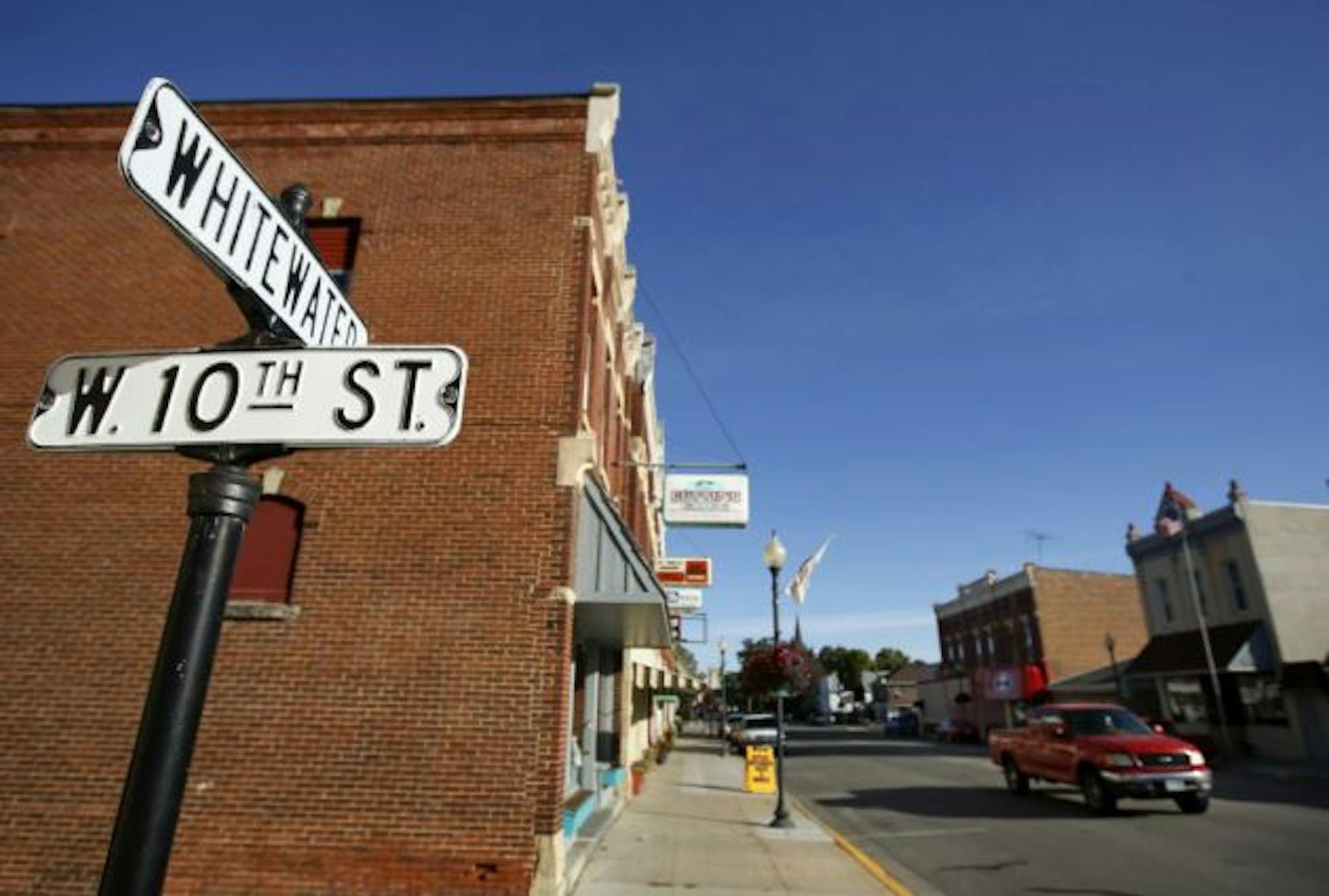 St. Charles, the small Minnesota town that sits half way between Rochester and Winona is at the center of possibly the largest porposed  frac sand wash plant and rail-loading facility which will be the gateway to intensive frac sand mining throughout the region. (IN THIS PHOTO) Downtown St. Charles is spruced up with melorial flower baskets and welcome flags hanging from the light posts. Known as the gateway to Whitewater State Park, the quiet bedroom community to Rochester and Winona could see dramatic change if hundreds of trucks per day start rolling through town. ]