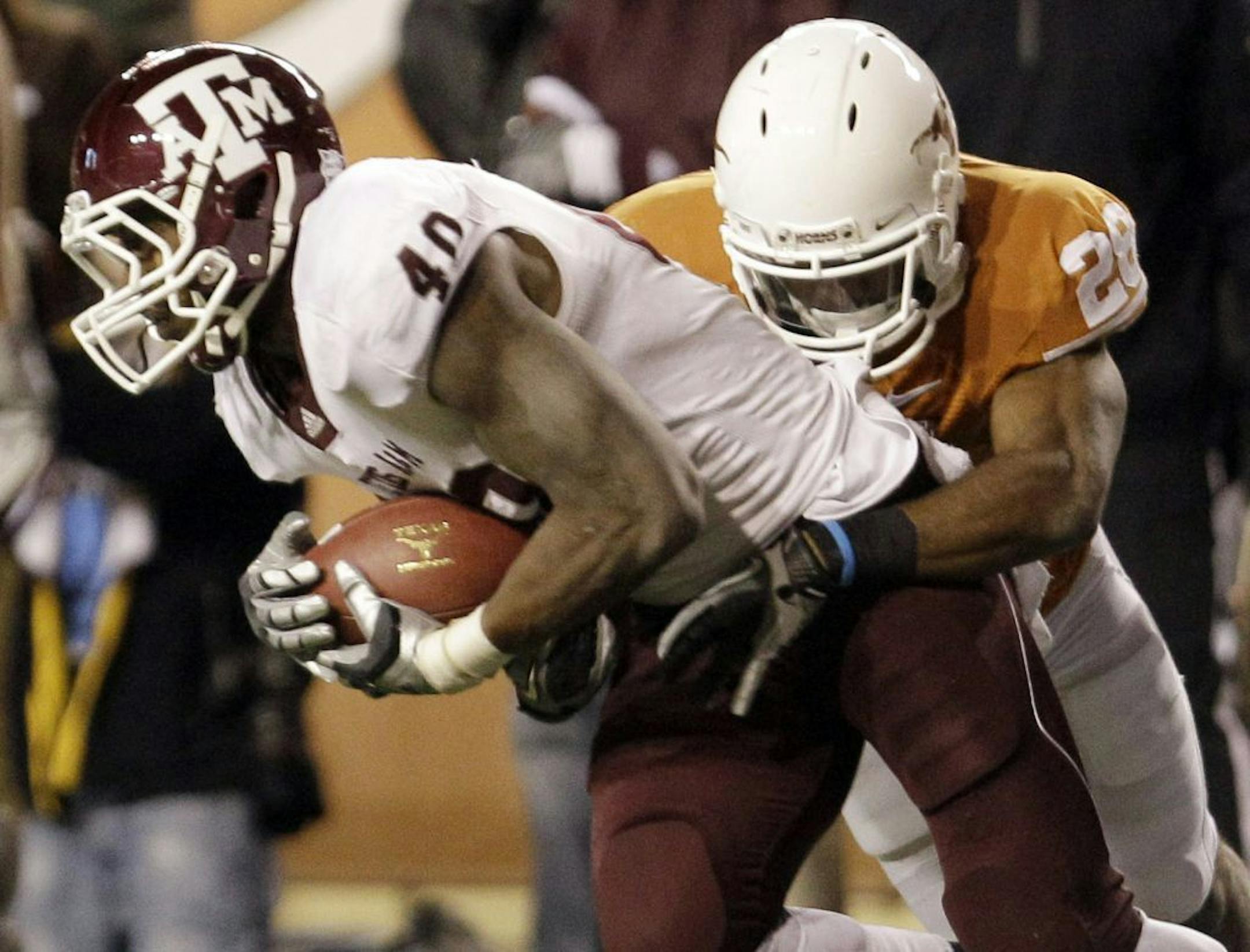 FILE - In this Nov. 25, 2010 file photo, Texas A&M's Von Miller (40) pulls down an interception as Texas' Fozzy Whittaker (28) stops him during the fourth quarter of an NCAA college football game in Austin, Texas. Miller is a top prospect in the upcoming NFL Draft.