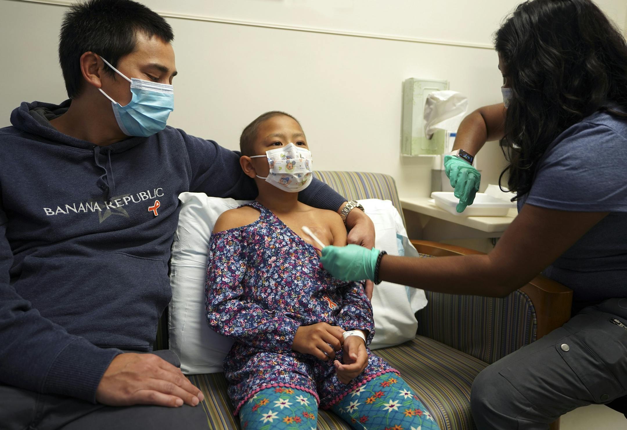 8 year old JoJo Truong sits next to her dad Jerome Truong, from Eagan getting the numbing cream before her injection as part of the Comfort Promise at the Cancer and Blood Disorders Clinic at ChildrenÕs Minnesota. Nurse in photos is Trinayani Freeberg, RN. ] Needles cause fear and anxiety for children, and their parents, but Children's Minnesota is reporting success in overcoming that obstacle. The pediatric provider is reporting results from the nation's first systemwide approach to elimin