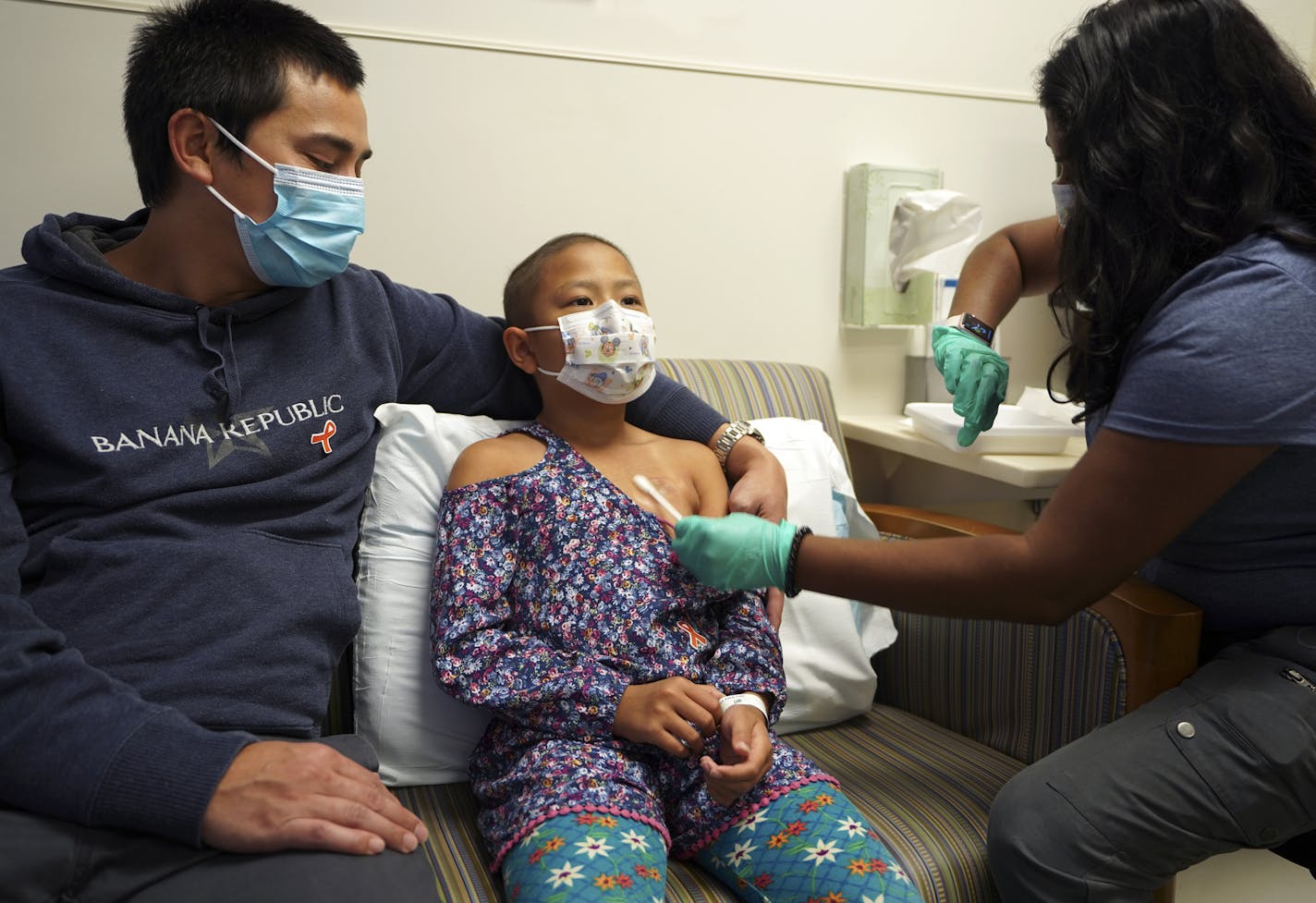 8 year old JoJo Truong sits next to her dad Jerome Truong, from Eagan getting the numbing cream before her injection as part of the Comfort Promise at the Cancer and Blood Disorders Clinic at Children&#xd5;s Minnesota. Nurse in photos is Trinayani Freeberg, RN. ] Needles cause fear and anxiety for children, and their parents, but Children's Minnesota is reporting success in overcoming that obstacle. The pediatric provider is reporting results from the nation's first systemwide approach to elimin