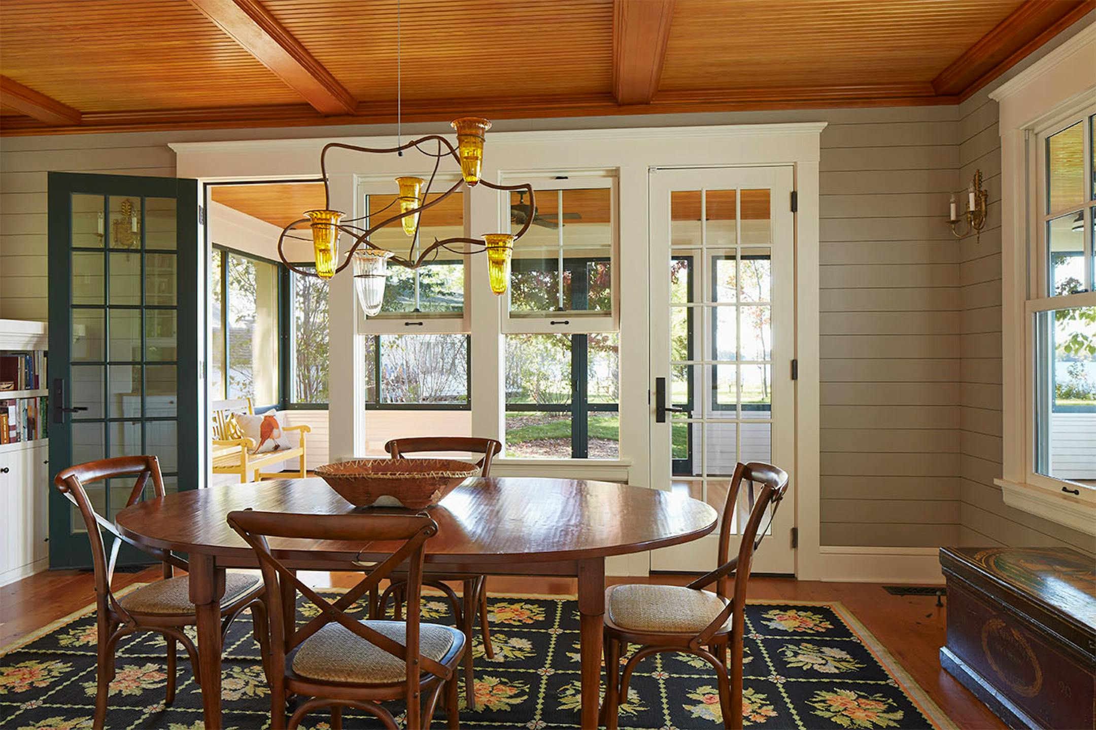 The dining room's iron oil lamp chandelier by local artist Connee Mayeron emits a warm amber glow on summer evenings