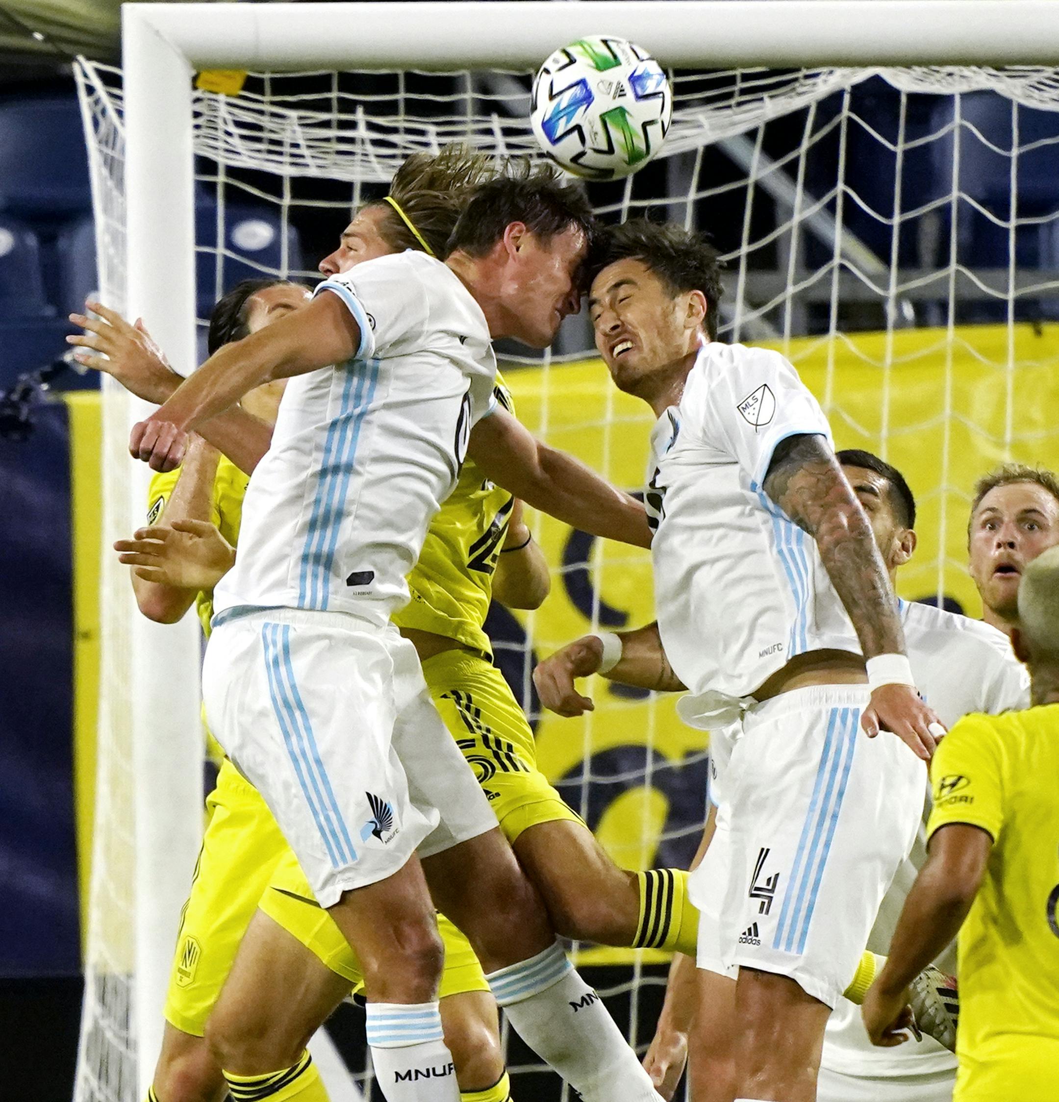 Minnesota United forward Aaron Schoenfeld, left, and defender Jose Aja (4) head the ball in front of the Nashville SC goal during the first half of an MLS soccer match Tuesday, Oct. 6, 2020, in Nashville, Tenn. (AP Photo/Mark Humphrey)