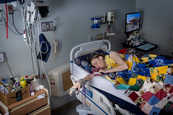 Cindy Hagen talks on the phone in her hospital room at the Mayo Clinic Hospital in Austin, Minn., on Wednesday, Jan. 25, 2023. Hagen has been confined