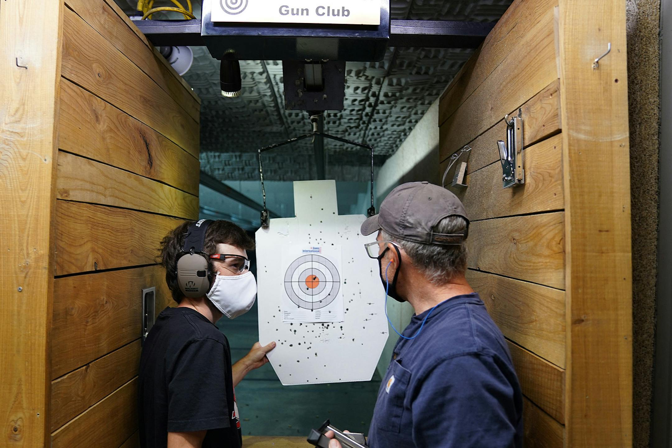 Hunter Woodward, left, talked with his dad Gary Woodward after they fired Gary's handgun during Hunter's first trip to the shooting range.