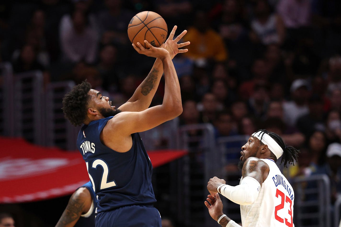 Minnesota Timberwolves center Karl-Anthony Towns, left, shoots against Los Angeles Clippers forward Robert Covington during the first half of an NBA preseason basketball game, Sunday, Oct. 9, 2022, in Los Angeles. (AP Photo/Raul Romero Jr.)