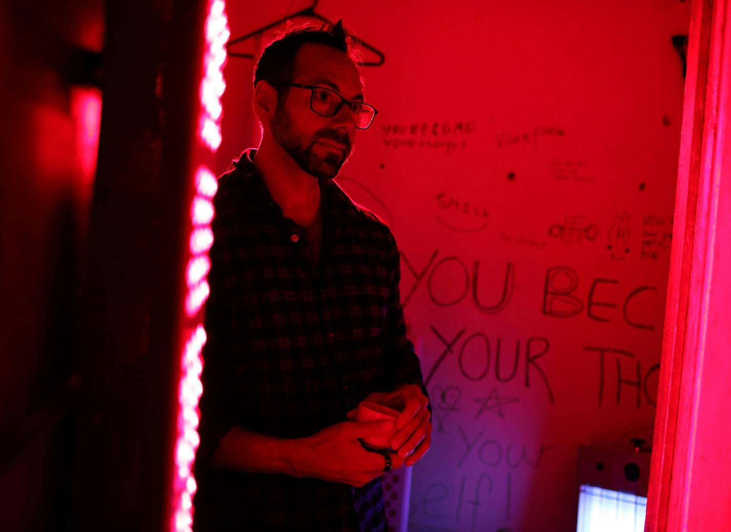 Biohacker Thaddeus Owen in a closet in the family's home where he bathes himself in red light each day before dawn.