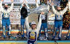 Chase Elliott holds up the season championship trophy as he celebrates with his race crew in Victory Lane