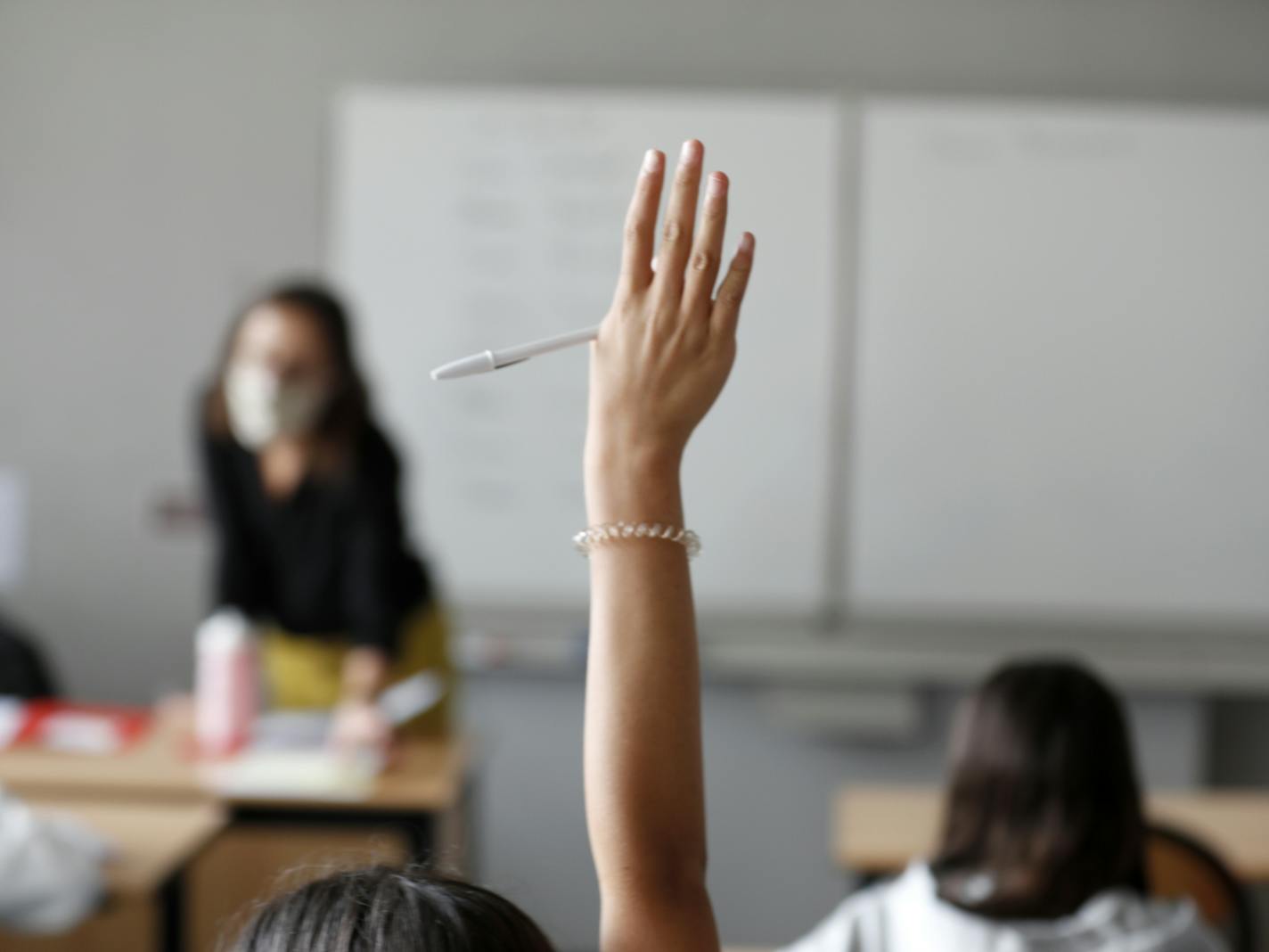 A schoolchild raises her arm to answer his teacher during a class in Bischheim, outside Strasbourg, eastern France, Tuesday, Sept.1, 2020. Millions of French children starting going back to class Tuesday despite a recent rise in virus infections, in a nationwide experiment aimed at bridging inequalities and reviving the economy. (AP Photo/Jean-Francois Badias)