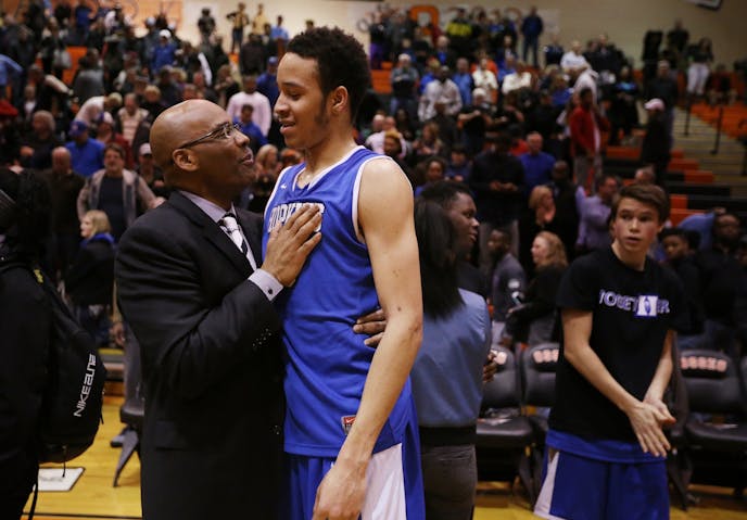 Amir Coffey of Hopkins celebrates with assistant coach Kerry Sutherland, left, after their win against Robbinsdale Cooper.