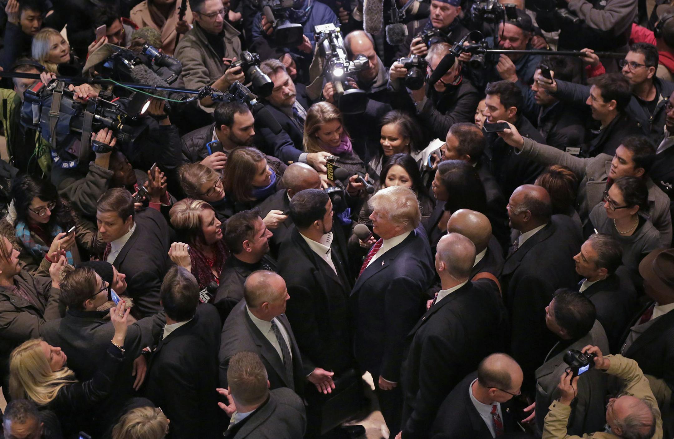 FILE - In this Monday, Nov. 30, 2015 file photo, Republican presidential candidate Donald Trump, center right, says goodbye to Dr. Darrell Scott, foreground left center, the senior pastor of New Spirit Revival Ministries in Cleveland Heights, Ohio, surrounded by media in the lobby of Trump Tower in New York, after meeting a coalition of 100 African-American evangelical pastors and religious leaders. (AP Photo/Richard Drew) ORG XMIT: NY452