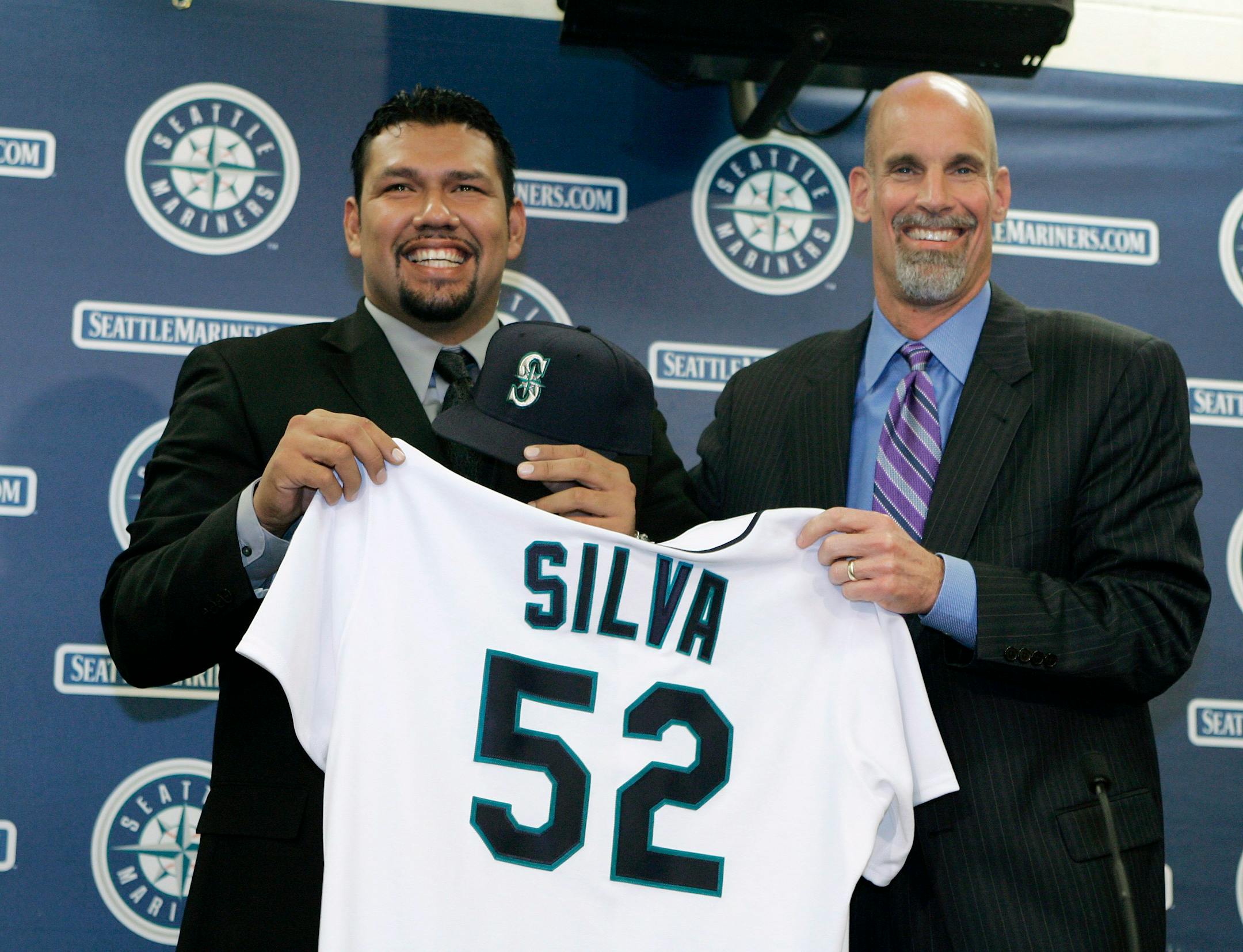 Seattle Mariners general manager Bill Bavasi, right, presented new Mariners pitcher Carlos Silva with a baseball jersey and cap Thursday