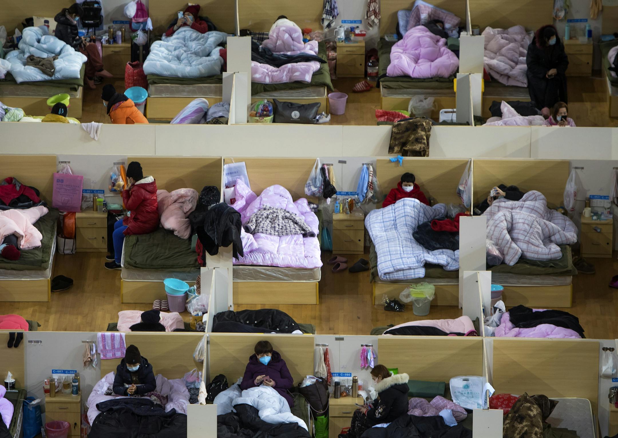 In this Monday, Feb. 17, 2020, photo released by Xinhua News Agency, patients infected with the coronavirus take rest at a temporary hospital converted from Wuhan Sports Center in Wuhan in central China's Hubei Province. China reported thousands new virus cases and more deaths in its update Tuesday on a disease outbreak that has caused milder illness in most people, an assessment that promoted guarded optimism from global health authorities. (Xiao Yijiu/Xinhua via AP)
