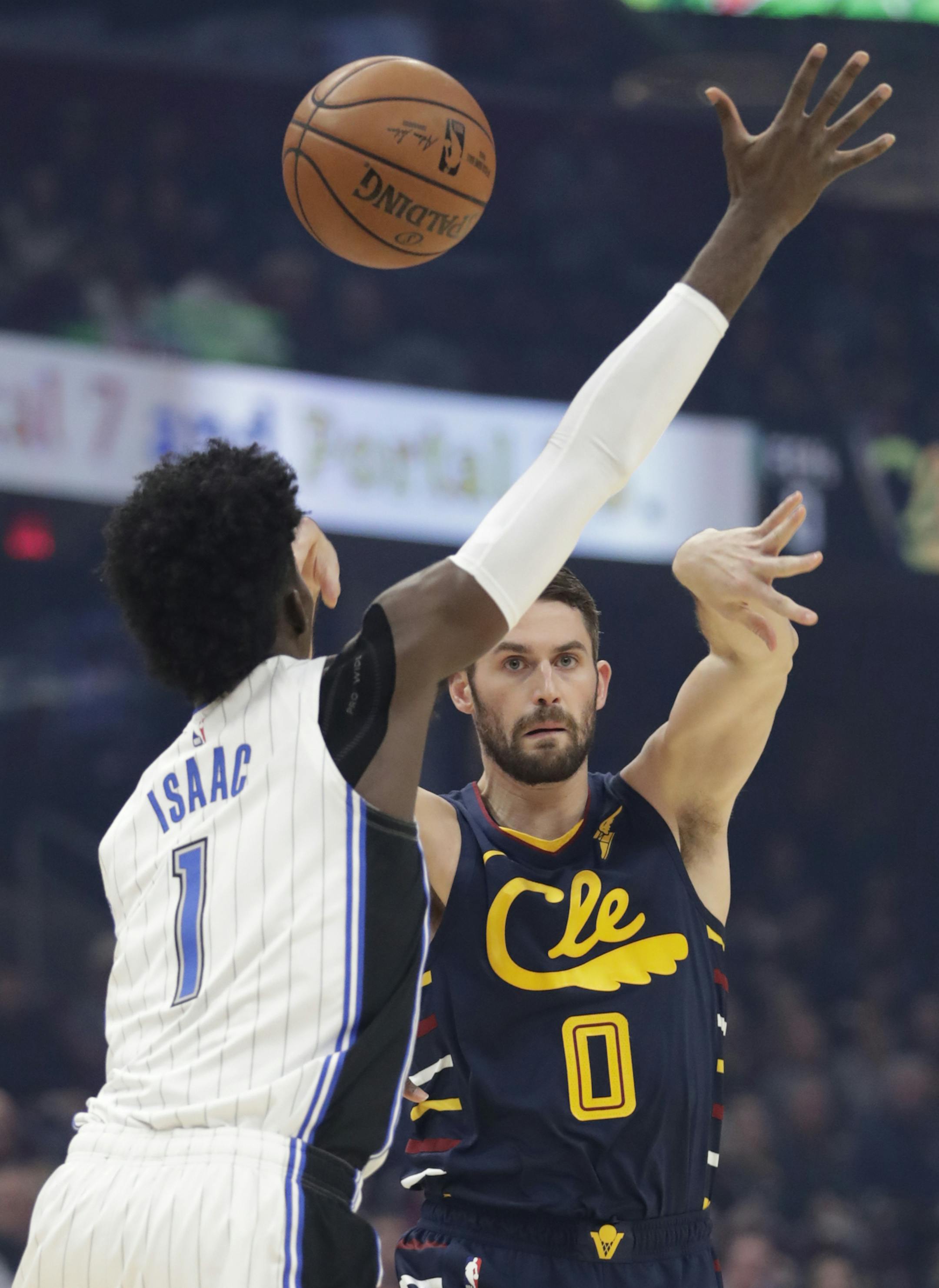 Cleveland Cavaliers' Kevin Love (0) passes over Orlando Magic's Jonathan Isaac (1) in the first half of an NBA basketball game, Wednesday, Nov. 27, 2019, in Cleveland. (AP Photo/Tony Dejak)