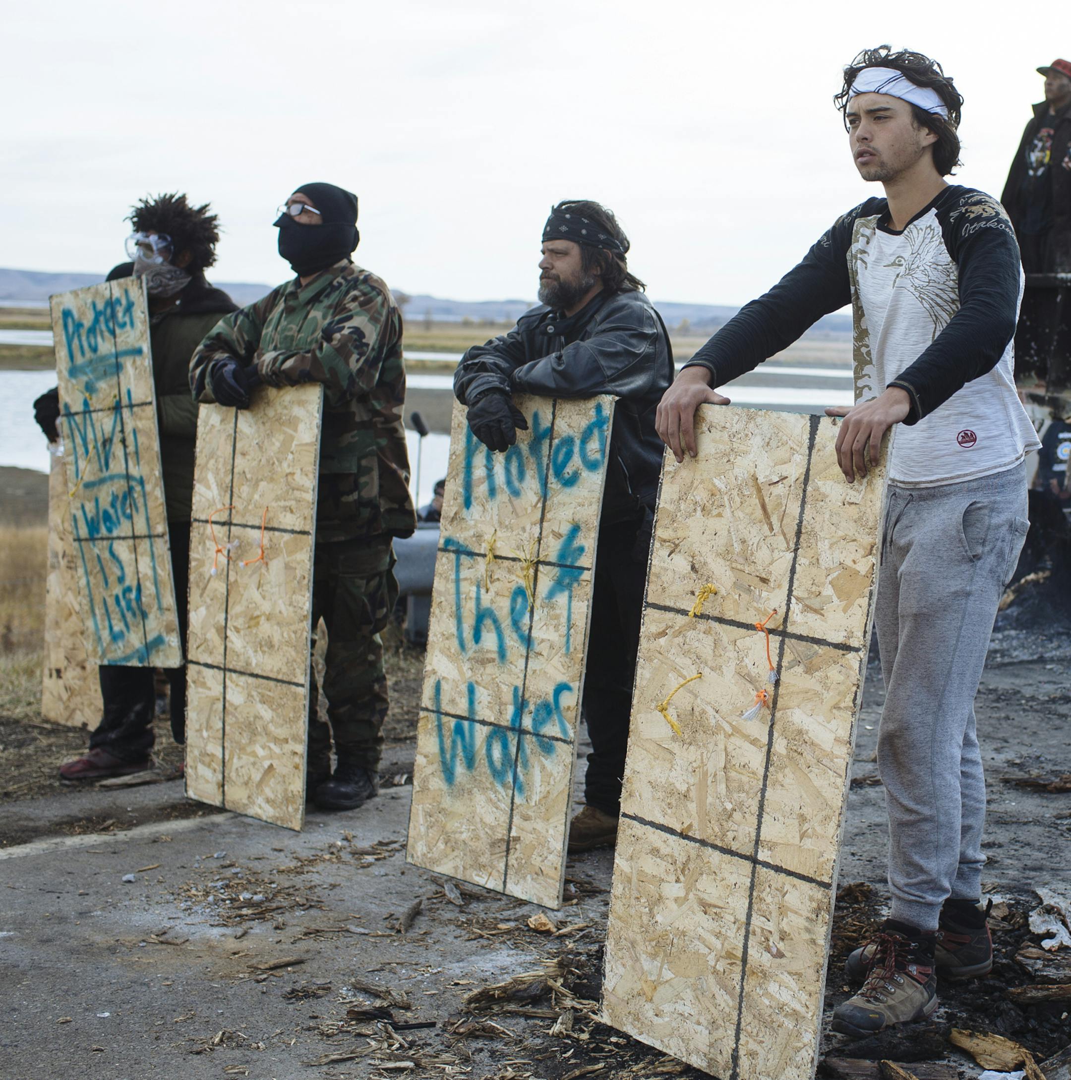 Protesters occupying a bridge face off against police, just north of the Standing Rock Sioux Reservation in Cannon Ball, N.D., Oct. 28, 2016. A day after tensions boiled over here in a conflict over the fate of the Dakota Access pipeline, police officers said Friday they had arrested at least 141 protesters, and both sides complained about violent tactics used by the other. (Angus Mordant/The New York Times)