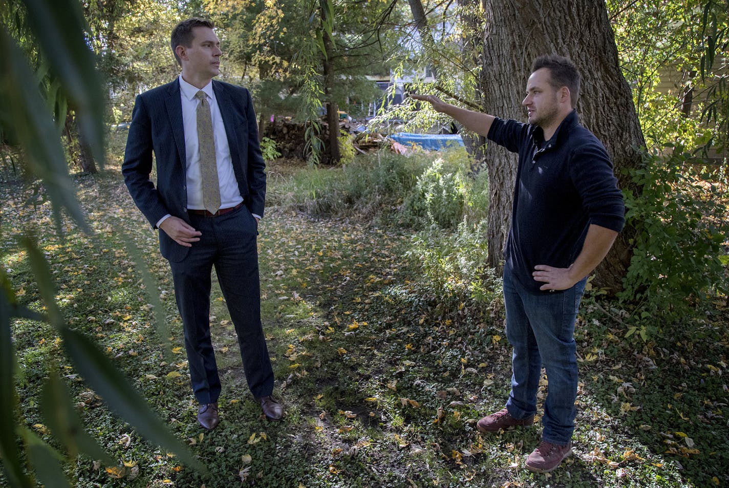 Josh Hague (right) and his attorney Andrew Pieper stood in his backyard, which has been flooding, do to an overflow of water. ] CARLOS GONZALEZ &#xef; cgonzalez@startribune.com - October 18, 2017, Mahtomedi, MN, Five Mahtomedi homeowners have sued the city, claiming officials reneged on a negotiated agreement to pay damages for a faulty street improvement project.